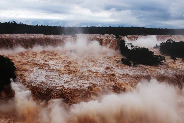 Fotografía que muestra las Cataratas del Iguazú hoy, ubicadas en la ciudad de Foz do Iguaçu, oeste de Paraná (Brasil). Debido a las fuertes lluvias que azotaron la región sur de Brasil, el caudal de agua en las Cataratas del Iguazú alcanzó el lunes unos 24.100 metros 
cubicos por segundo. El promedio normal es de 1 millón 500 mil litros por segundo. Como medida de seguridad, a la pasarela que da acceso al mirador de la Garganta do Diabo se le retiró parte de su barandilla de protección y permanece cerrada, al igual que los ascensores y pasarelas inferiores. EFE/Christian Rizzi
