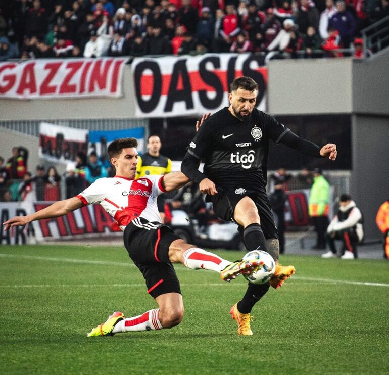 Duelo de argentinos. El delantero  Lucas David Pratto (36 años) intenta avanzar ante la cobertura defensiva de Federico Gattoni (25). Foto Olimpia