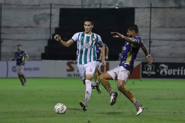 El zaguero albiverde, Javier Vallejos intenta la salida ante la marca del atacante Ronald Acuña. (Foto: APF)