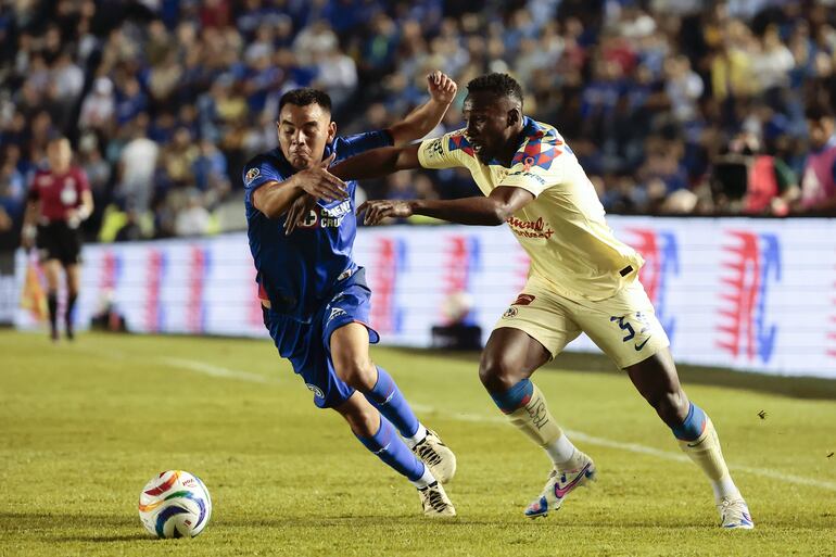 AME8420. CIUDAD DE MÉXICO (MÉXICO), 23/05/2024.- Carlos Rodríguez (i) de Cruz Azul disputa el balón con Julián Quiñones de América este jueves, durante el partido de ida de la final del Torneo Clausura del fútbol mexicano realizado en el Estadio Ciudad de los Deportes en Ciudad de México. EFE/ José Méndez
