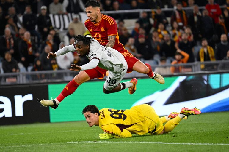 Bayer Leverkusen's Dutch defender #30 Jeremie Frimpong (C) tries to score against Roma's Serbian goalkeeper #99 Mile Svilar during the UEFA Europa League semi final first leg football match between AS Roma and Bayern Leverkusen at the Olympic stadium on May 2, 2024 in Rome. (Photo by Alberto PIZZOLI / AFP)