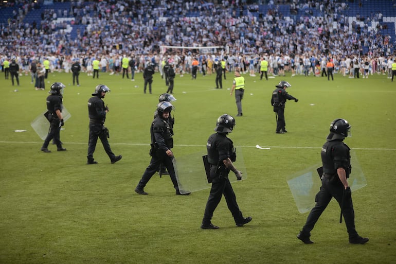 Agentes de policía desalojan el Stage Front Stadium tras el partido entre el Espanyol y el Oviedo por el ascenso a LaLiga EA Sports, este domingo en Cornellà de Llobregat (Barcelona).
