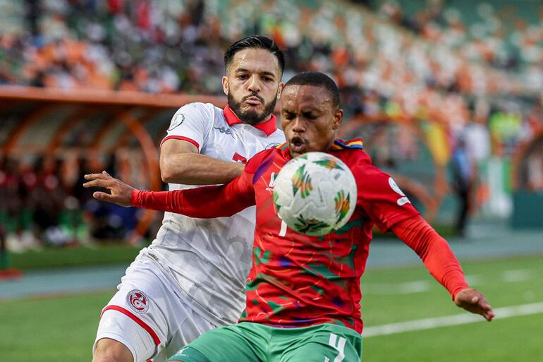 Riaan Hanamub (d), de Namibia, disputa el balón con Wajdi Kechrida, de Túnez, durante el partido jugado ayer en Costa de Marfil.