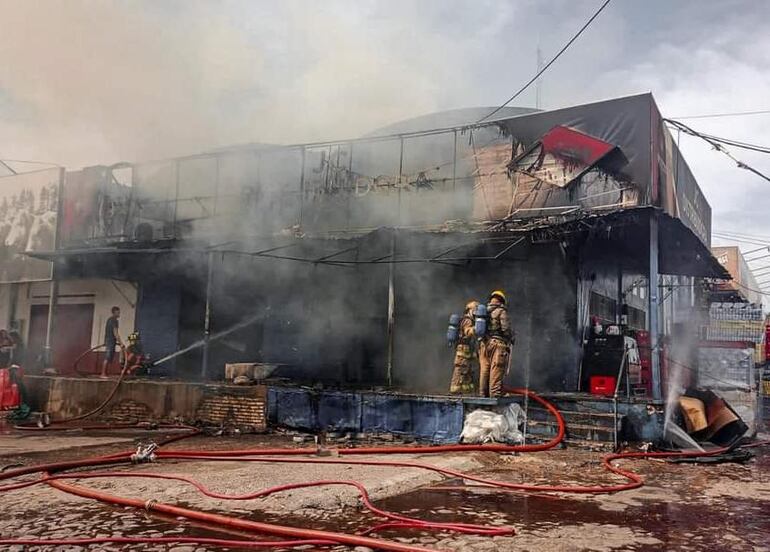 Bomberos dentro de lo que quedó del local comercial JC. (gentileza).