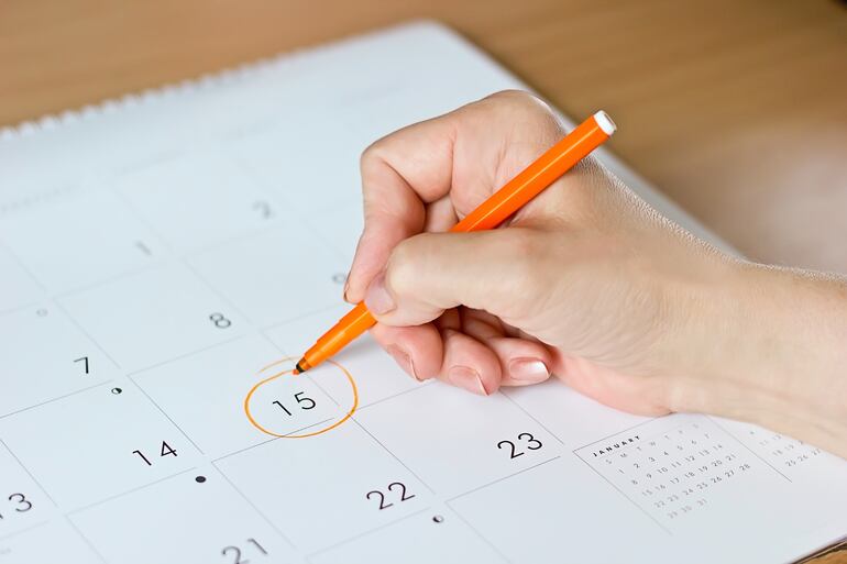 Una mujer marca el 15 de un mes en un calendario.