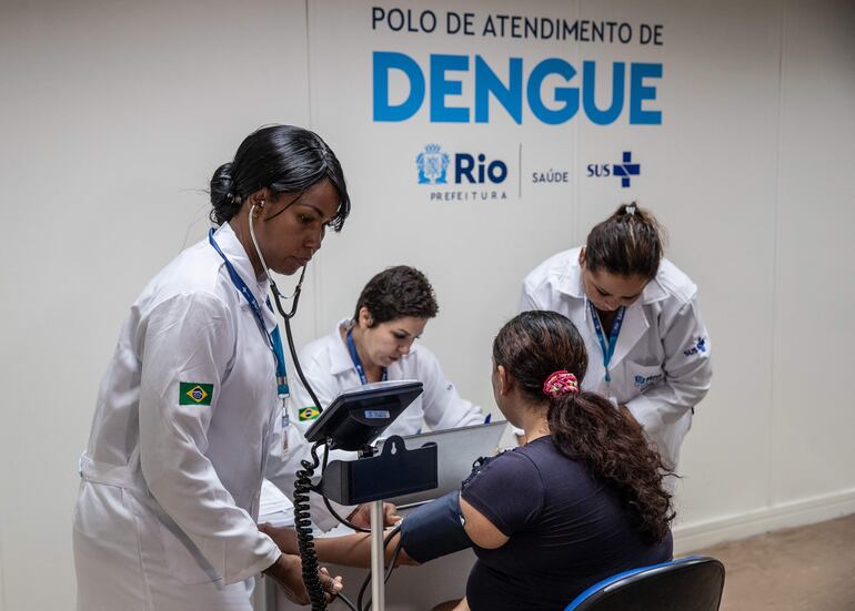 Trabajadores de la Salud revisan a una paciente sospechosa de dengue hoy, en el Centro de Atención de Dengue de la Policlínica Rodolpho Rocco, en el barrio Del Castilho, en Río de Janeiro (Brasil). Brasil, que enfrenta un fuerte aumento de los casos de dengue, tomó este martes nuevas medidas sanitarias en ciudades como Brasilia, Río de Janeiro o São Paulo, que se encuentran entre las regiones más afectadas por esta enfermedad que ha causado la muerte de 36 personas desde el comienzo del año. Desde el 1 de enero, Brasil ha registrado 345.235 casos de dengue con 36 fallecimientos confirmados, a los que se suman 234 muertes en investigación, según los datos oficiales. EFE/ André Coelho
