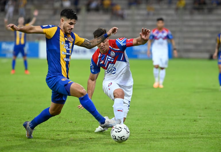 Eduardo Duarte, futbolista de Sportivo Luqueño, y Diego Churín, jugador de Cerro Porteño, pelean por el balón en un partido por la séptima jornada del torneo Clausura 2023 del fútbol paraguayo en el estadio Villa Alegre, en Encarnación.