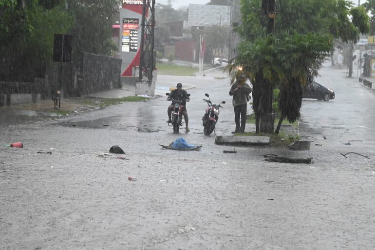 Motociclistas no pueden cruzar la vía ante la lluvia.