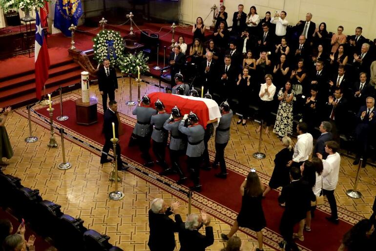 Agentes de la escolta presidencial sostienen el ataúd con el cuerpo del expresidente de Chile Sebastián Piñera hoy.