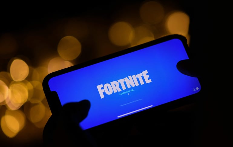 Una persona iniciando sesión en Fortnite de Epic Games en su teléfono inteligente. Un juez de San Francisco (EE.UU.) ordenó este lunes al gigante tecnológico Google que facilite la entrada de competidores en la Play Store, su ‘tienda’ para descargar aplicaciones que viene por defecto en los dispositivos Android y que ha sido objeto de una demanda antimonopolio en los últimos años.