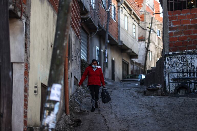 Una mujer camina por la villa 21 en el barrio de Barracas, Buenos Aires, 10 de junio de 2022. (Foto: Juan Ignacio Roncoroni / EFE)
