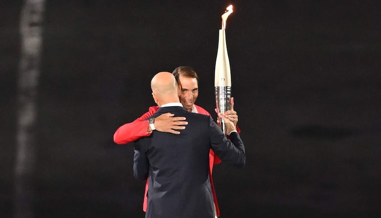 Zinedine Zidane (frente) entrega la antorcha olímpica a Rafael Nadal (atrás) en Trocadero durante la ceremonia de apertura de los Juegos Olímpicos de París 2024, en París, Francia, 26 de julio de 2024.