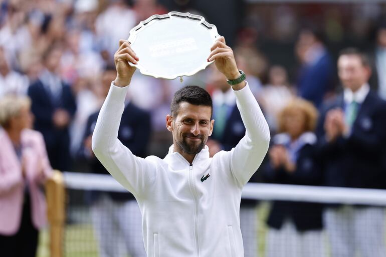 El tenista serbio Novak Djokovic celebra con el trofeo del vicecampeón de Wimbledon después de perder la final con el español Carlos Alcaraz en Wimbledon, Londres, Inglaterra.