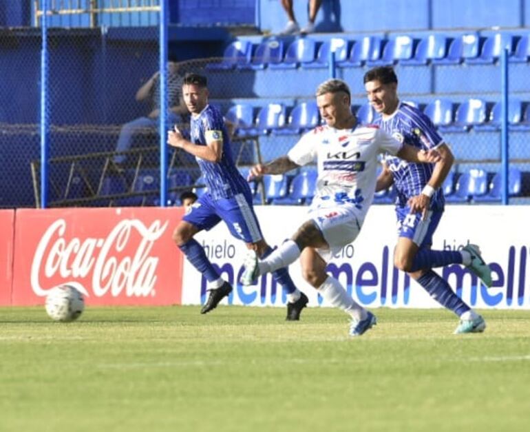 Facundo Velazco trata de meter el balón al área con la marca de Acosta