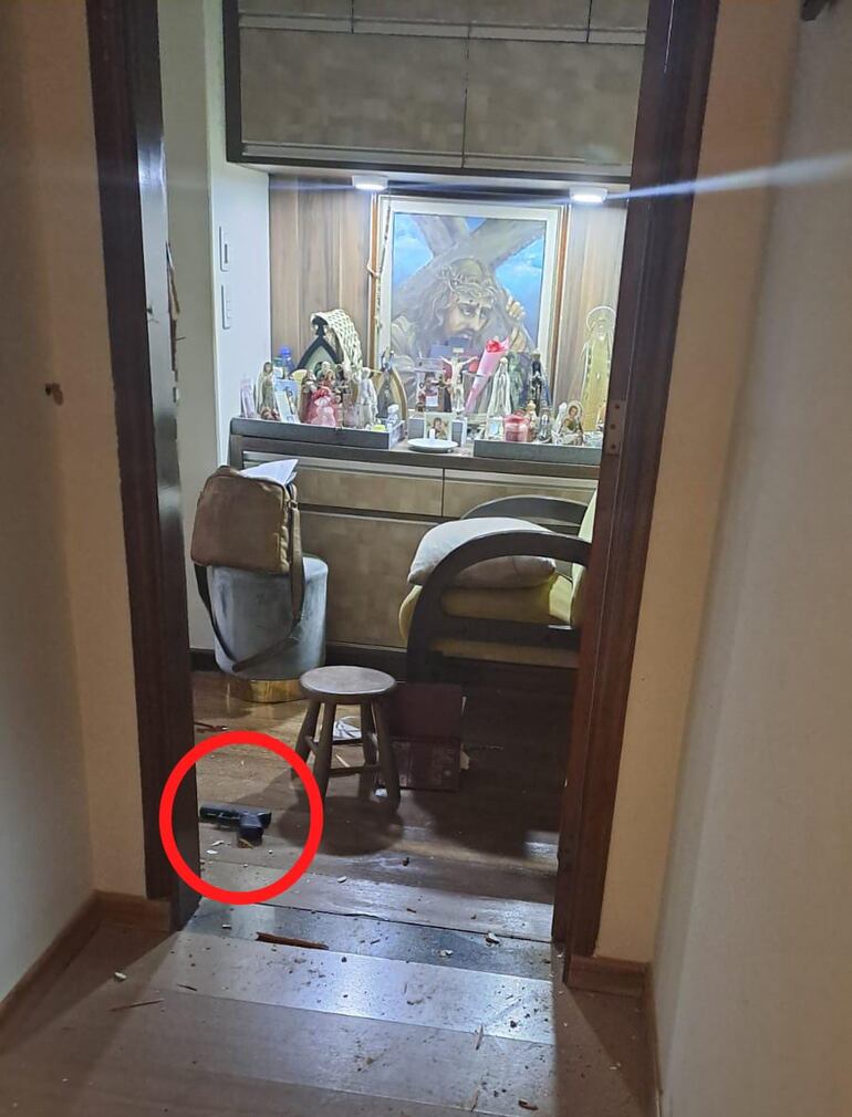 En el suelo de la habitación del diputado cartista Eulalio "Lalo" Gomes se observa la pistola con la que habría disparado esta madrugada. De fondo, un pequeño altar.