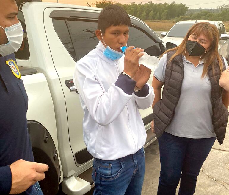 Esposado, el indígena Jonny Paredes Gauto toma agua, antes de ser trasladado a su lugar de reclusión. La Fiscalía lo imputó ayer y pide prisión para el mismo.