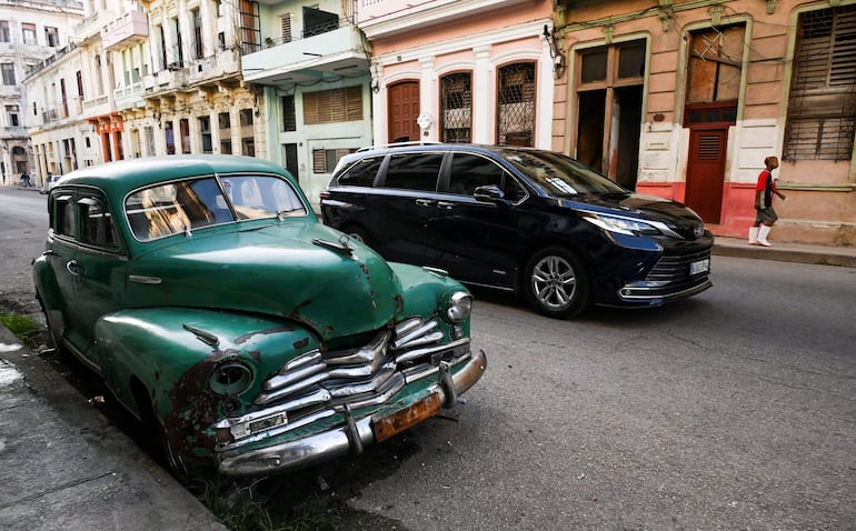 Un automóvil moderno pasa junto a un viejo automóvil estadounidense estacionado en una calle de La Habana. Flamantes Mercedes Benz, camionetas pick up, jeeps Wrangler y hasta algunos Tesla: en medio de una fuerte crisis económica en Cuba, coches de alta gama han comenzado a robar protagonismo a los clásicos americanos de la década de 1950 y a los compactos Lada y Moskvich soviéticos.