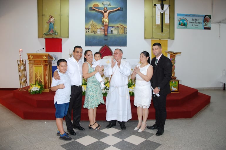 El nuevo cristiano Matías Orué Reyes con sus padres, su hermanito Santiago, el sacerdote que celebró el bautismo y sus padrinos. (Gentileza)