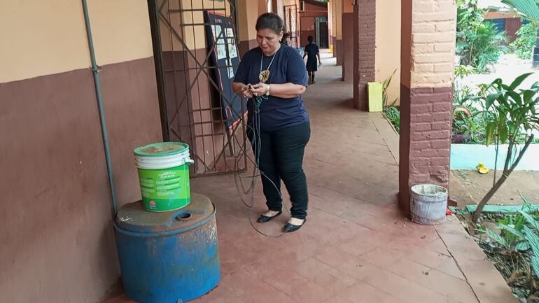 La directora José Dolores, muestra los restos de cables que quedaron tirados en el suelo y que no fueron llevados por los malvivientes.