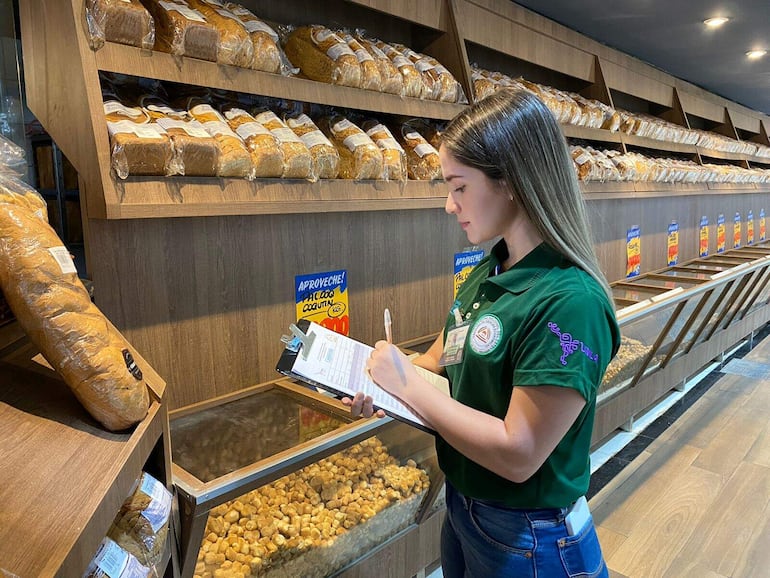 Una estudiante de la Universidad Nacional del Este anota los precios de los productos de la canasta básica familiar.