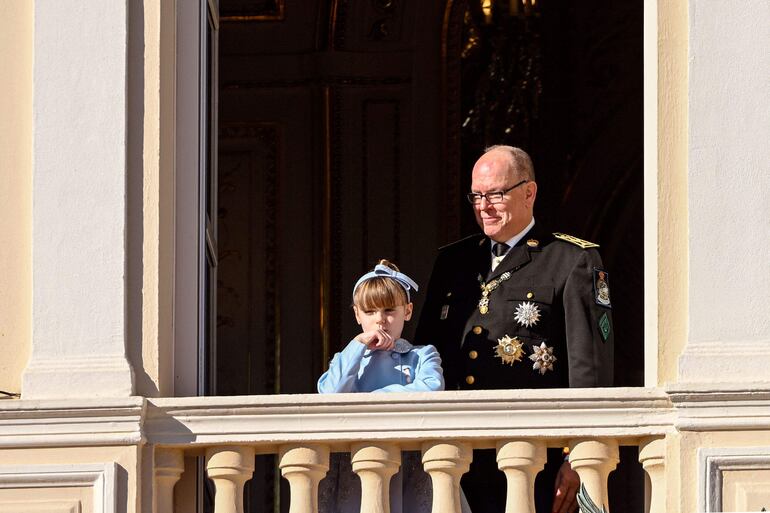 El Príncipe Alberto II de Mónaco y su hija, la princesa Gabriella, saludan a la multitud desde el balcón durante las celebraciones del "Día Nacional de Mónaco". (Frederic DIDES / AFP)