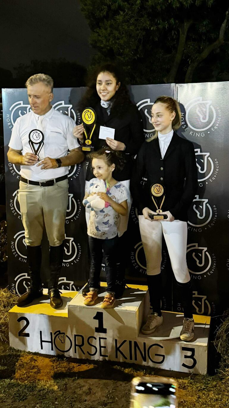 Alejandro Laitán (i), María Belén Giménez la campeona y María Lange Lloret, los laureados en la prueba especial 1.25.