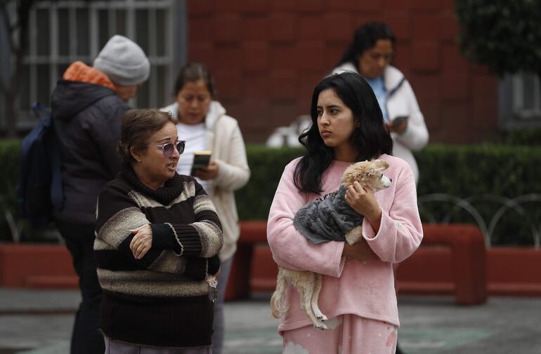 Personas permanecen fuera de sus hogares después de escuchar la alerta sísmica hoy. Un sismo de magnitud 5,8 con epicentro en Puebla, estado del centro de México, activó este jueves la alerta sísmica de Ciudad de México y sacudió diferentes zonas del país.