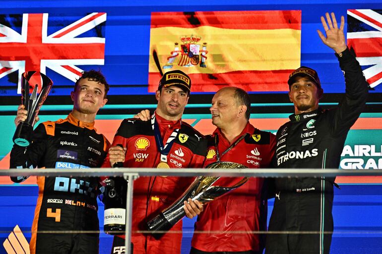 El español Carlos Sainz Jr (segundo de izq. a der.) celebra el triunfo del Gran Premio de Singapur 2023 con Lando Norris (i) y Lewis Hamilton (d) en el Circuito Urbano de Marina Bay. 