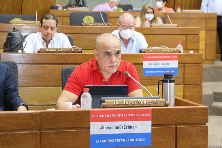 Invasión es crimen dice el cartel que porta Basilio Núñez, quien creó un esquema para apropiarse de numerosos terrenos municipales a terceros. 