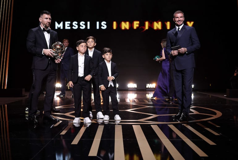 Lionel Messi y sus tres hijos recibiendo el Balón de Oro en París. Muy cerca se ve a un sonriente David Beckhham. (FRANCK FIFE/AFP)