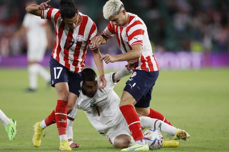 El jugador de Marruecos Hakim Ziyech (c) juega un balón desde el suelo entre Jesús Medina (i) y Julio Enciso, ambos de Paraguay, durante el partido amistoso entre las selecciones de Marruecos y Paraguay disputado este martes en el estadio Benito Villamarín, en Sevilla.