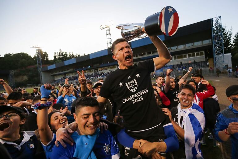 El paraguayo Cris Martínez, futbolista de Huachipato, celebra con el trofeo de campeón de la Primera División de Chile, en el estadio CAP, en Talcahuano, Chile..