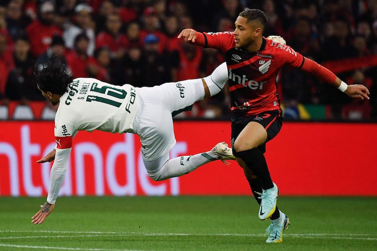 El paraguayo Gustavo Gómez (L) del Palmeiras y Vitor Roque del Athletico Paranaense compiten por el balón durante el partido de ida de la semifinal de la Copa Libertadores, en el estadio Arena da Baixada, en Curitiba, Brasil, el 30 de agosto de 2022.
