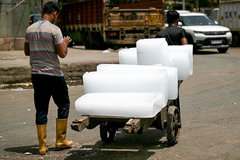 Un hombre transporta bloques de hielo este jueves en Nueva Delhi.