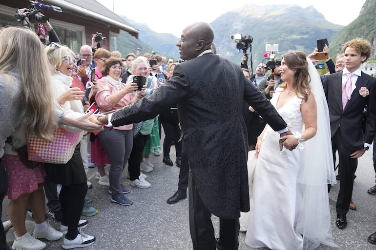 Martha Louise (segunda de la derecha) y Durek Verrett saludan a la muchedumbre a su arribo a su fiesta de bodas.