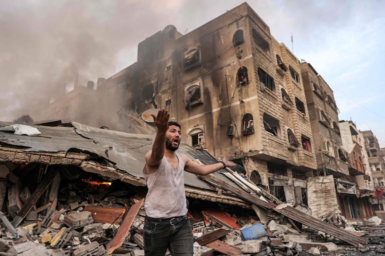 Un hombre junto a un edificio colapsado tras un bombardeo israelí en la Ciudad de Gaza, este miércoles.