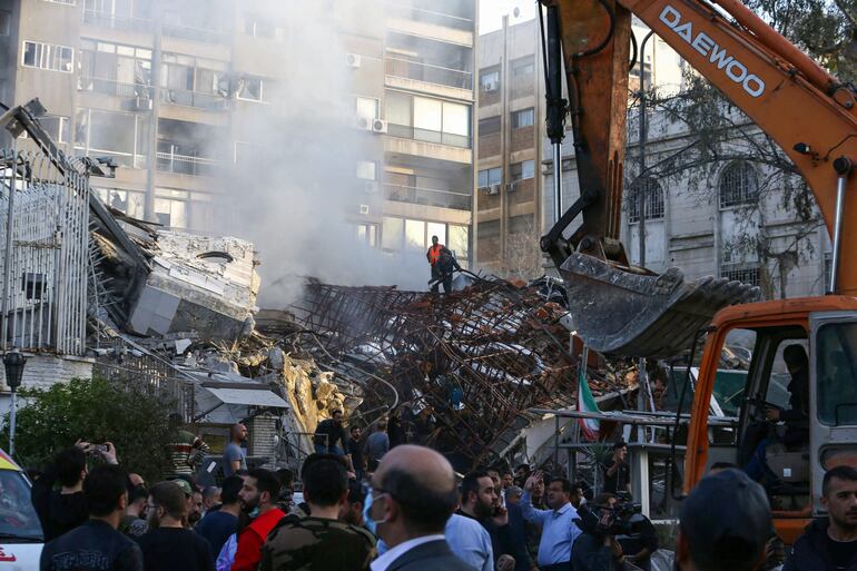 El personal de emergencia y de seguridad inspecciona los escombros en el lugar de los ataques que impactaron en un edificio anexo a la embajada iraní en la capital de Siria, Damasco, el 1 de abril de 2024.