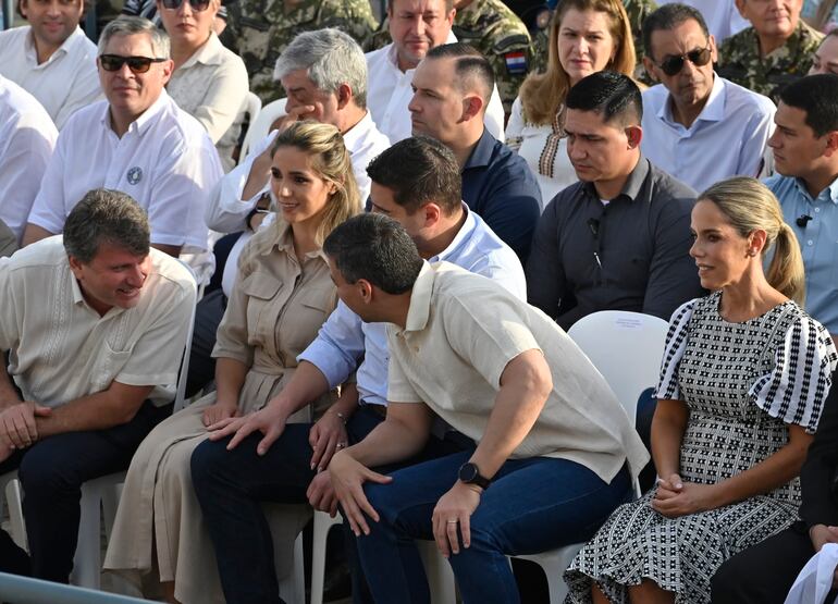 El presidente Santiago Peña (de espaldas) dialoga animadamente con Denis Lichi durante la misa de Caacupé. En medio, el vicepresidente Pedro Alliana y su esposa y diputada, Fabiana Souto (todo ANR; HC).