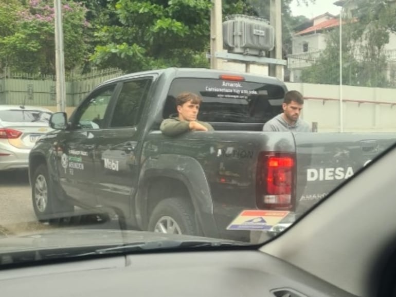 Javier Garrido (d), jugador de Pádel, en la parte trasera de una camioneta oficial del evento en la calles de Asunción.