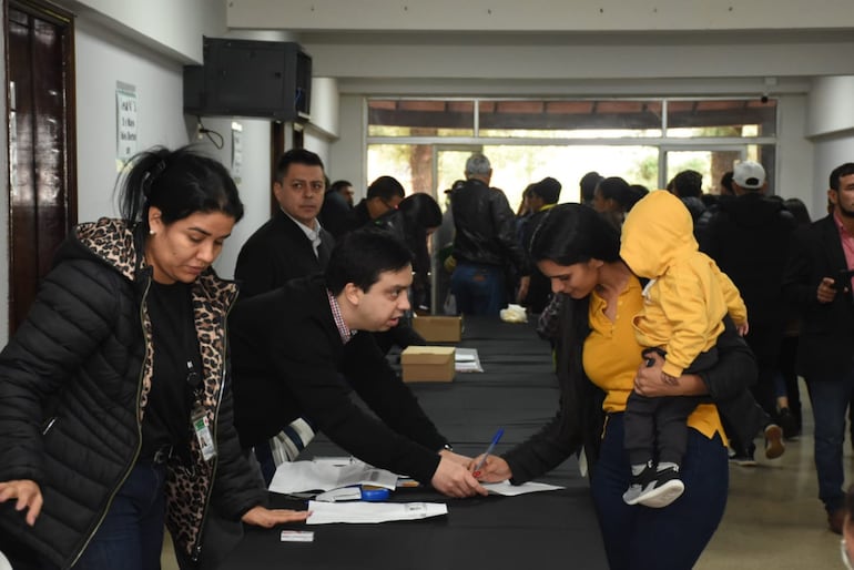 Laura Talavera, estudiante becada, firma la planilla para recibir el dinero para solventar sus estudios.