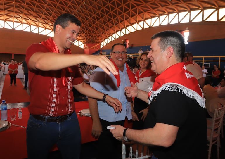 El presidente de la República, Santiago Peña (izq.) se acerca a abrazar al titular de la ANR, Horacio Cartes, ayer en Itapúa.