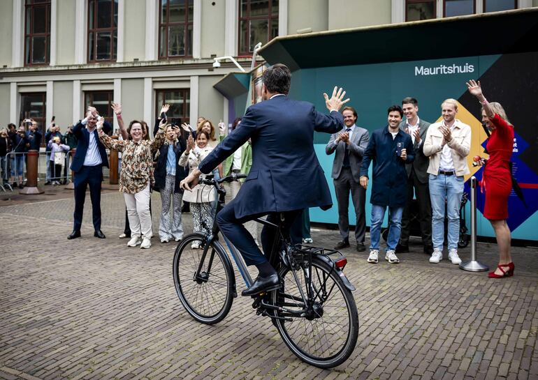 El exprimer ministro de Países Bajos, Mark Rutte saluda a los funcionarios mientras se retira de su oficina en bicicleta. 