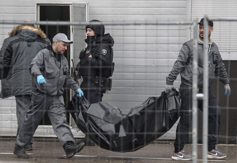 Trabajadores sanitarios llevan uno de los cuerpos de las víctimas del tiroteo en la sala de conciertos del Crocus City Hall en Krasnogorsk, a las afueras de Moscú, este sábado.