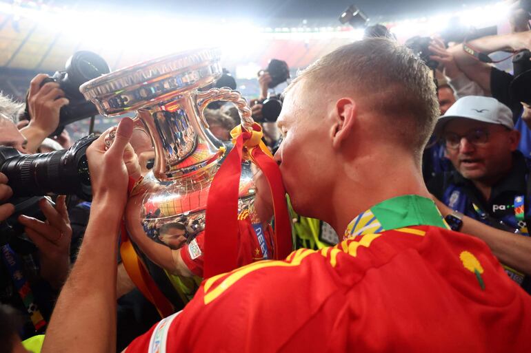 Dani Olmo celebra besando su trofeo de la UEFA EURO 2024.