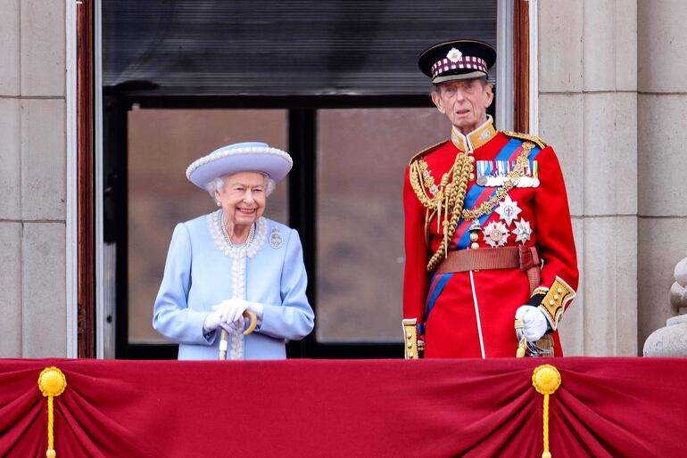 Vestida con abrigo y sombrero azul, la monarca británica apareció en el balcón del  Palacio de Buckingham sonriente y de pie junto a su primo, el duque de Kent,  coronel de la guardia escocesa. (AFP)