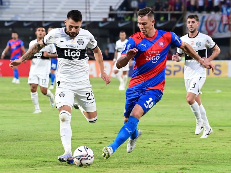 Víctor Salazar (i), defensor de Olimpia, lucha por el balón con Diego Churín, delantero de Cerro Porteño, en el superclásico del fútbol paraguayo por la sexta fecha del torneo Apertura 2023.