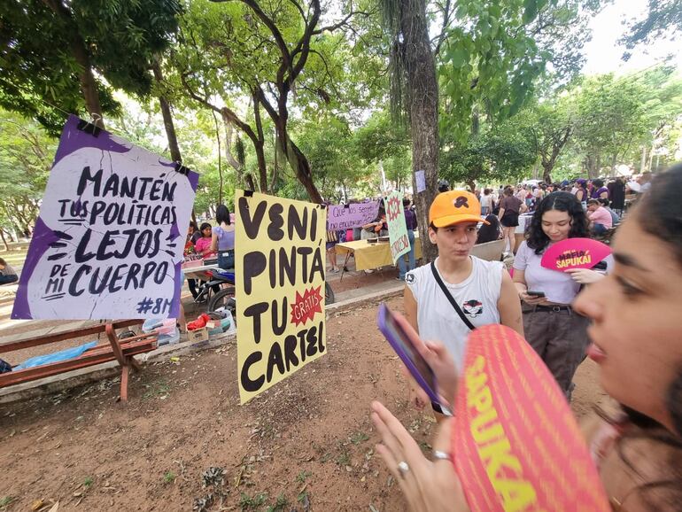 Mujeres se preparan para la marcha 8M en la plaza Uruguaya del microcentro de Asunción.