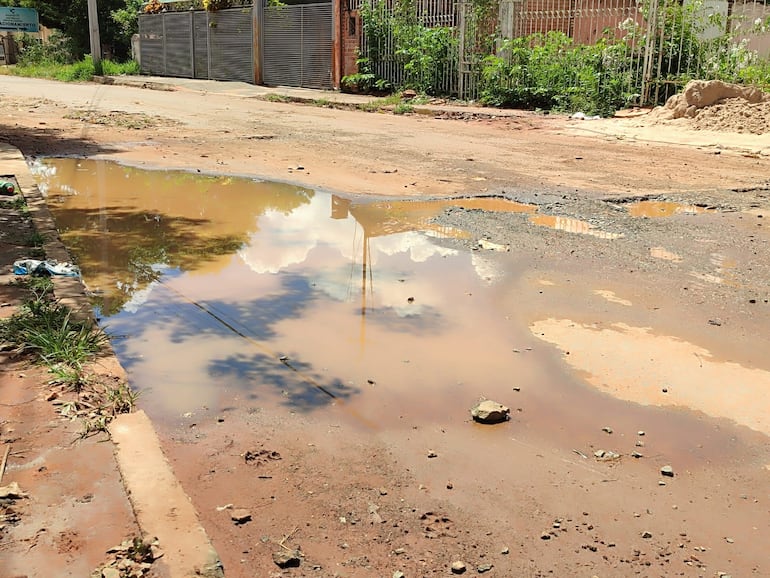 Las calles con baches se llenan de agua por las lluvias.