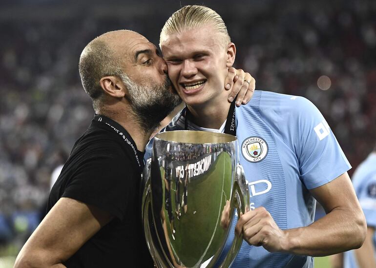 Pep Guardiola le da un beso a Erling Haaland, que sostiene la Supercopa de Europa, conquistada ayer por el Manchester City.