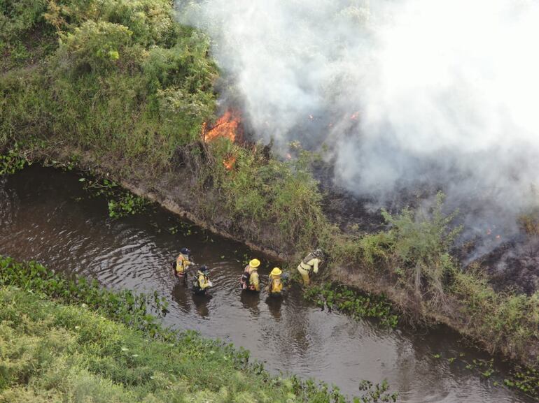 Bomberos voluntarios intentan apagar las llamas de un foco de calor. Gentileza Infona.